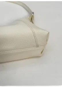 Detail of white litchi pattern leather bag showing reinforced wide bottom structure