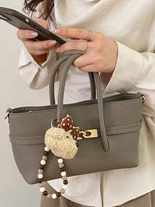 Minimalist dark gray pebbled leather handbag with cute bear charm and metal buckle detail
