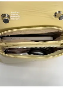 Top view of yellow leather bag interior showing compartments for smartphone and daily essentials