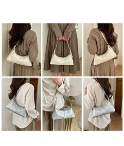 Detail showing creamy white and silver crescent bags with zip closure and slim straps