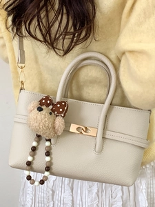 Minimalist beige pebble leather tote bag with gold lock and cute bear charm pendant