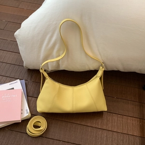 Detail of yellow lychee grain leather crescent bag with stitching and silver hardware