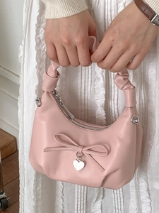 Pink minimalist half-moon bucket bag with chain strap and heart charm detail