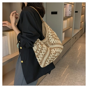 Detailed view of the hand-woven floral tote bag worn over the shoulder by a model