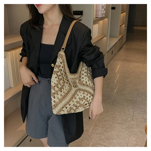 Detail of hand-woven hollow pattern and brown leather strap on large crochet tote bag