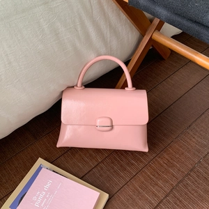 Pink minimalist crossbody bag with refined leather texture and elegant square metal clasp