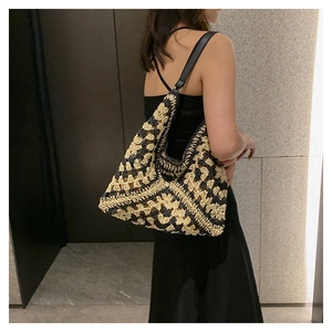 Detail of the woven pattern and black leather strap on a large crochet tote bag