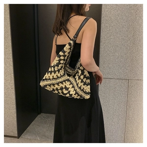 Close-up of handmade crochet shoulder bag showing black and beige woven textures