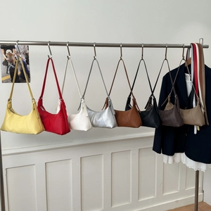 Row of colorful leather hobo bags in eight shades showing texture and zipper detail