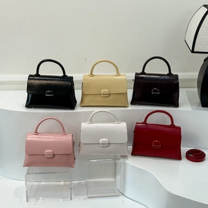 Detailed collection of square handbags in six colors on minimalist white steps