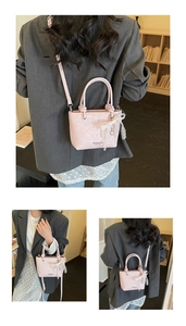 Borsa a mano rosa in ecopelle con fiocco di pizzo e pendente a cuore in uso