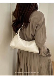 Close-up of cream white lychee texture leather handbag with stylish stitching details