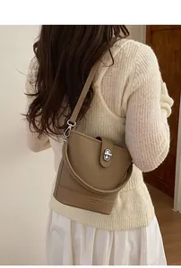 Detail of khaki bucket bag showing the lychee grain leather and silver twist lock closure