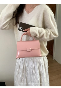Pink glossy patent leather handbag with retro metal buckle and minimalist handle design