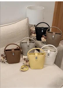 Detail of colorful bucket bags with lychee texture and cute bear charm accessories