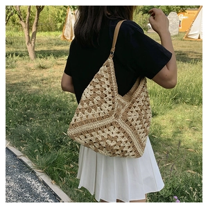 Close-up of handmade woven straw tote bag with geometric pattern and leather strap