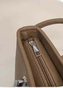 Close-up of premium brown pebble leather bucket bag with solid metal zipper detail