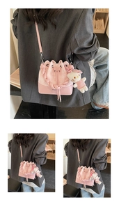 Pink drawstring bucket bag with star embroidery and a plush kitten charm detail