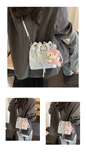 Detail of light blue plaid bucket bag featuring a star embroidery and plush charm