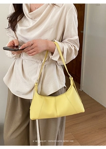 Close-up of bright yellow lychee leather bag with silver buckle worn on shoulder