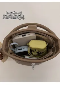 Top view of brown bucket bag showing spacious interior with umbrella and phone