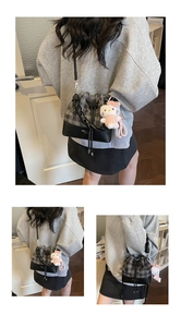 Detail of plaid bucket bag with drawstring closure and cute plush kitten pendant