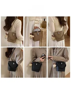 Detailed views of women's bucket bag showing top handle, twist lock, and puppy charm