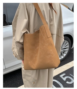 Dettaglio della borsa tote in ecopelle marrone caramello con cuciture eleganti sulla tracolla