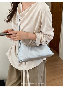 Detail of silver lychee grain leather hobo bag with retro three-seam design and slim strap