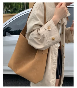Dettaglio di una borsa tote oversize marrone in pelle opaca per il pendolarismo quotidiano