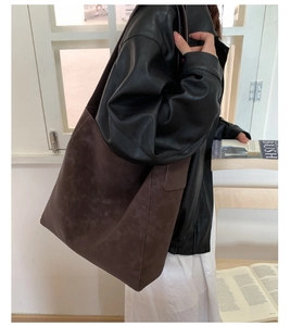 Borsa tote marrone scuro opaca vista di lato su una modella per un look quotidiano