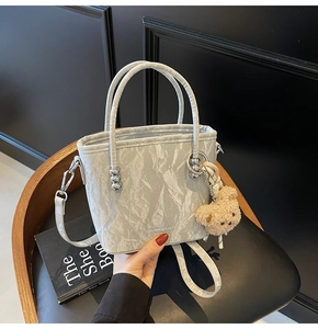 Détail du sac seau plissé argenté avec charm ours en peluche et bandoulière réglable