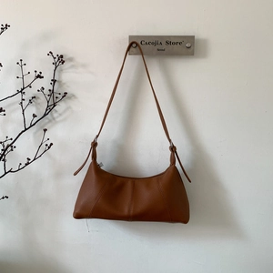 Close-up detail of caramel brown shoulder bag showing premium pebble grain leather texture