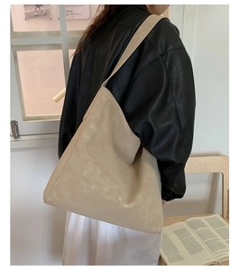 Dettaglio della trama della borsa tote beige minimalista con tracolla larga e finta pelle morbida