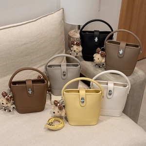 Detail of trendy bucket bags in six colors with leather texture and teddy bear charms