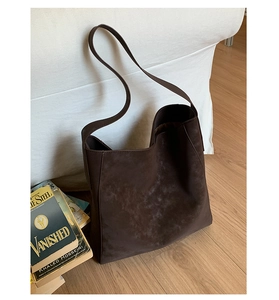 Dettaglio di una borsa tote grande marrone scuro in pelle scamosciata opaca da casa