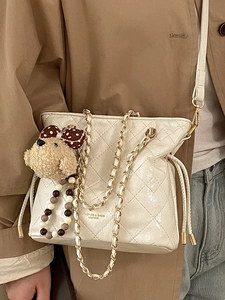 Quilted beige chain shoulder bag in glossy finish with cute teddy bear charm