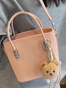 Sac seau rose minimaliste avec bandoulière réglable et décoration de charme d'ours en peluche