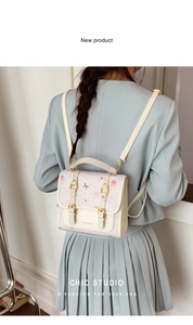 Detail view of stylish cream mini backpack with cartoon prints and adjustable straps