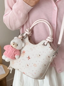 Trendy cream bucket bag with cute cat prints and a bear charm for women 2026 fashion