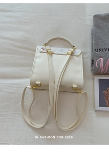 Detail view of the backpack back showing adjustable straps and gold metal hardware