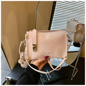 Détail du sac à bandoulière rose clair avec garniture dorée et charm ours en peluche