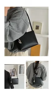Detailed views of a black minimalist underarm bag with a silver crescent metal charm