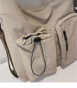 Detail of crossbody bag with functional drawstring pocket and durable canvas texture