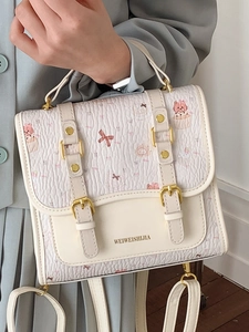 Preppy cream cartoon backpack with cat prints and textured fabric carried by a model