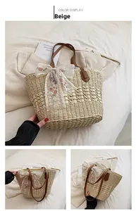 Detail of handmade straw tote with white lace bow and red rose floral embroidery
