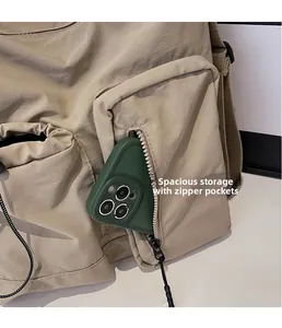 Detail of khaki nylon crossbody bag featuring front zipper pockets for smartphone storage