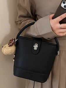 Fashionable black lychee grain leather bucket bag with silver twist lock and dog charm
