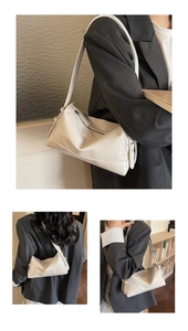 Detail of white minimalist underarm bag in glossy leather worn with a grey blazer
