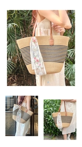 Detail of straw tote bag featuring black stripes and white floral lace ribbon detail